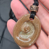 Earthy ceramic fossil pendant to show size
