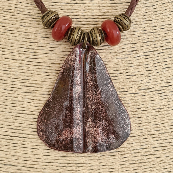 Detail of hammered enamelled copper pear pendant