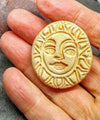 Ceramic sun brooch being held to show size